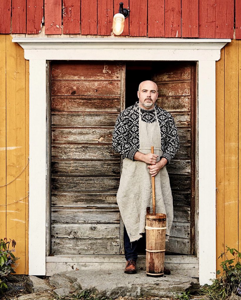 Jon Fredrik Skauge with a butter churn in the barn doorway at Fannremsgården